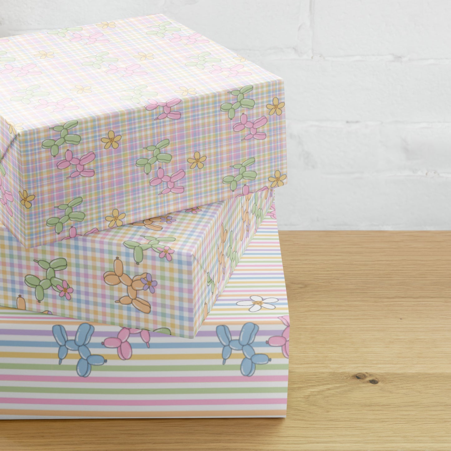 Pastel-colored gift wrap paper with balloon dog designs on a wooden surface.